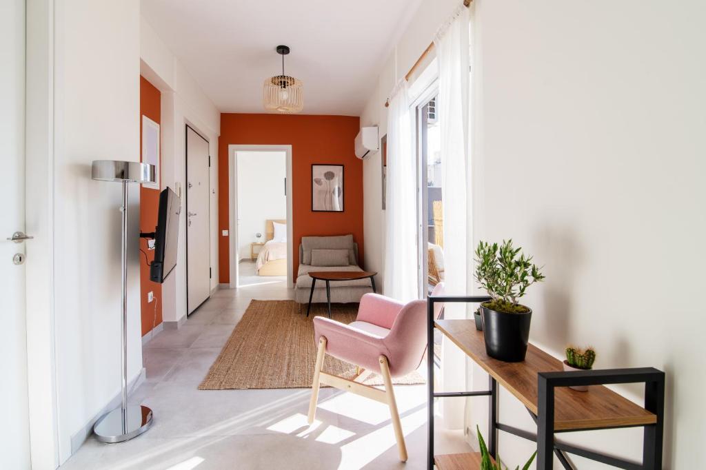 una sala de estar con una silla rosa y una mesa. en Cosy and stylish apartment in the centre, en Atenas