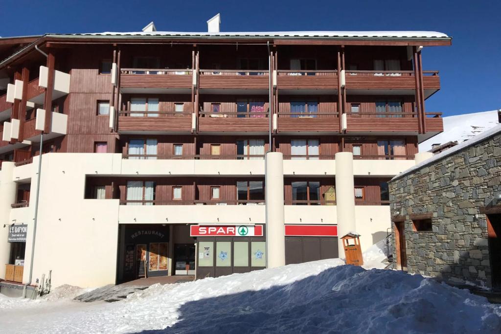 a building with a pile of snow in front of it at Bright studio with balcony in Aime-La Plagne