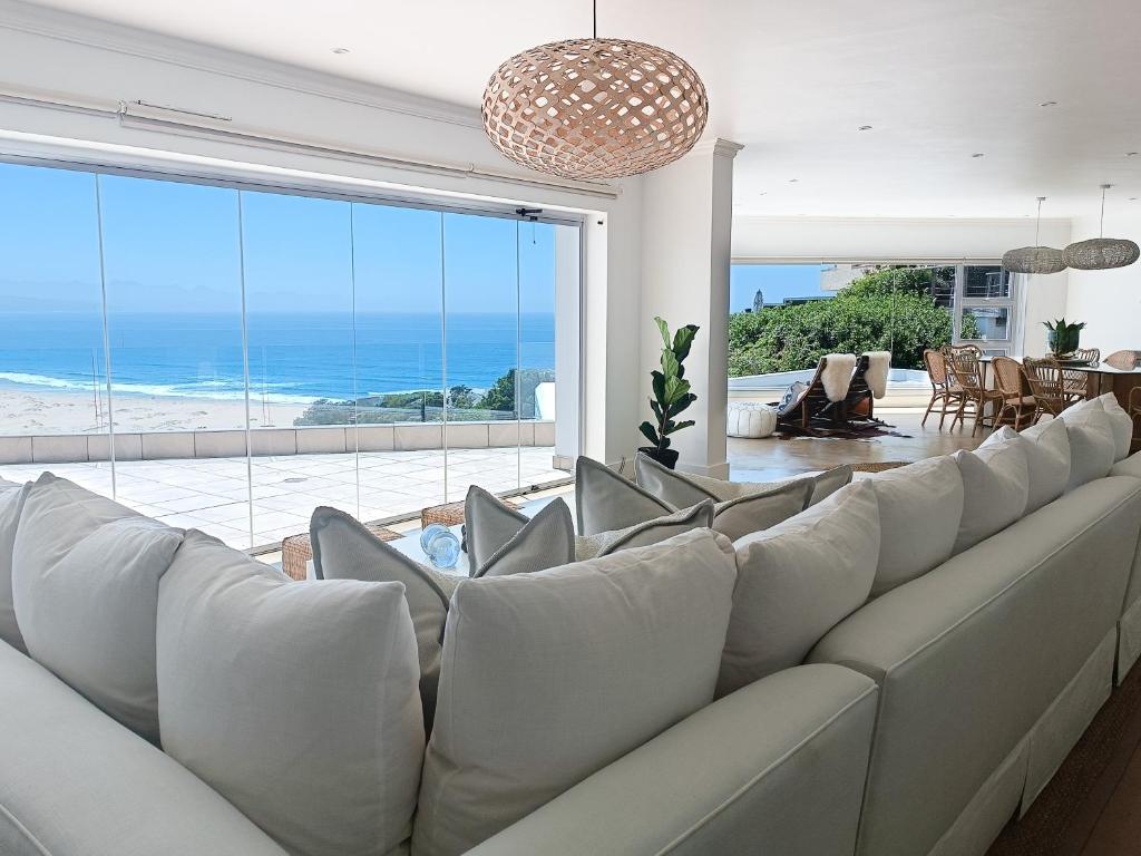 a living room with a large couch and a view of the ocean at Haven On Hill in Plettenberg Bay