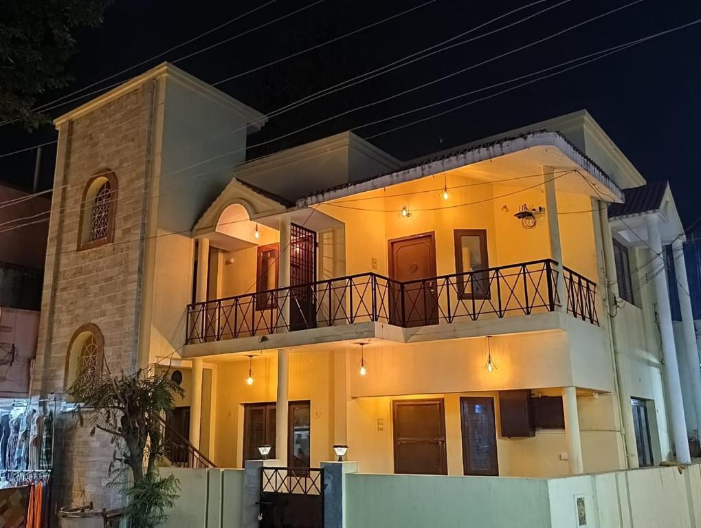 a large white house with a balcony at night at Agnisthala Guest House in Tiruvannāmalai