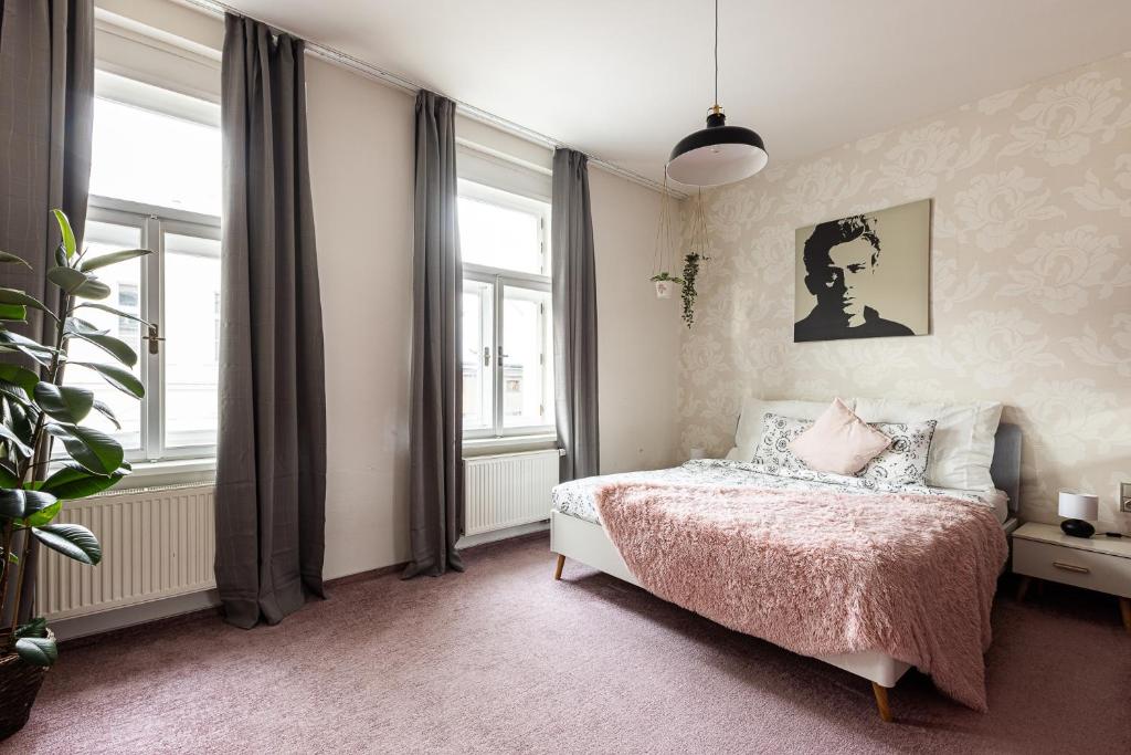 a bedroom with a bed with a pink blanket at Nice big apartment 2bds - Belgicka in Prague