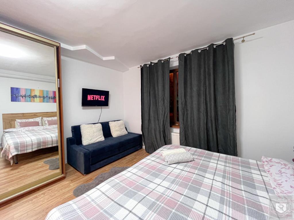 a bedroom with a bed and a mirror and a couch at Renthouse Apartments City Gates #2 in Chişinău