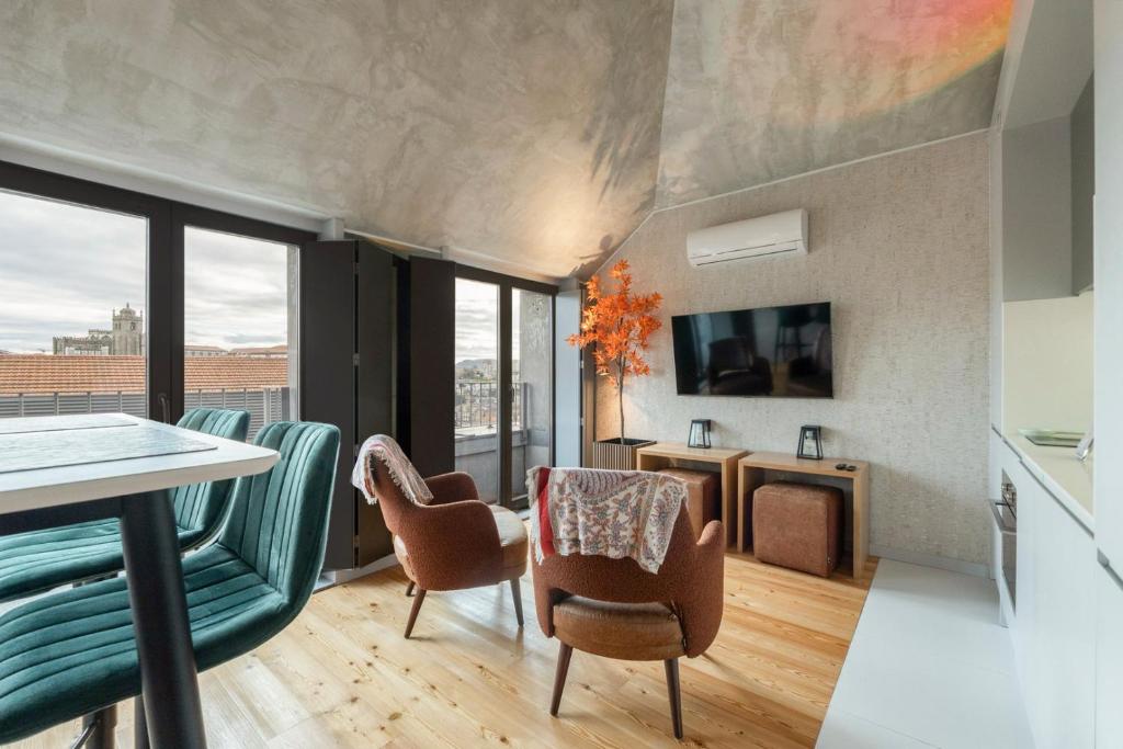 uma sala de estar com cadeiras, uma mesa e uma televisão em GuestReady - Elegant living in Porto city centre no Porto