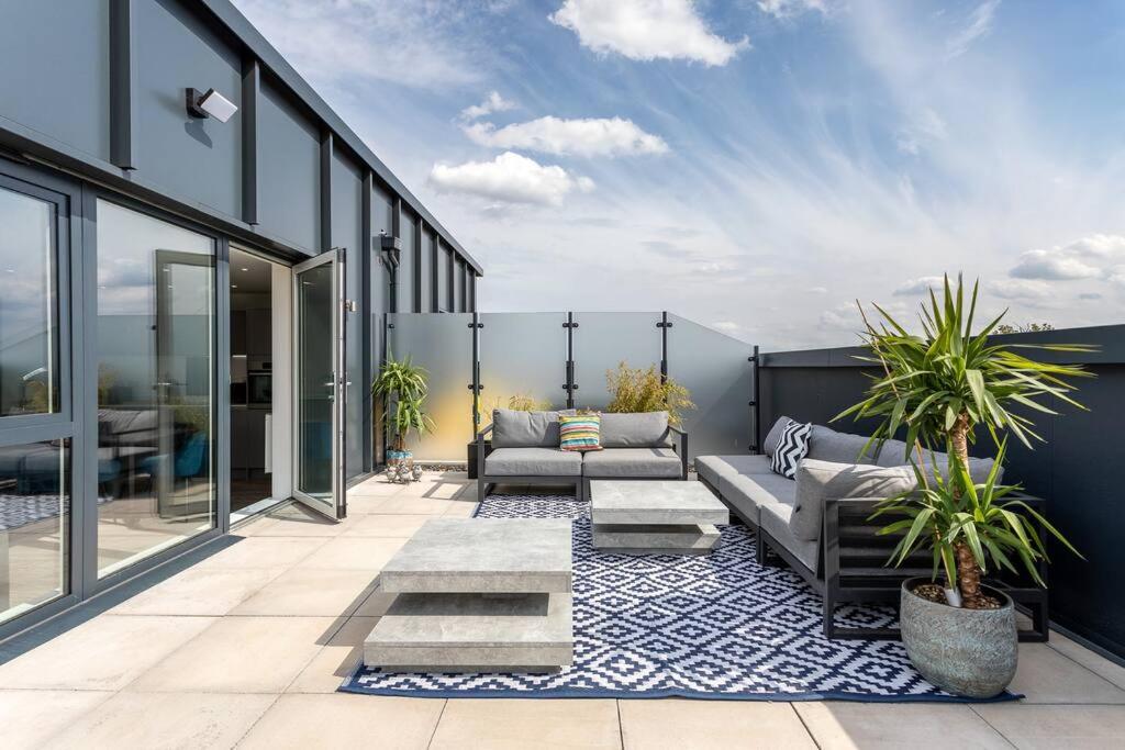 a patio with couches and plants on a building at Finsbury Park Penthouse: Luxe City Living in London