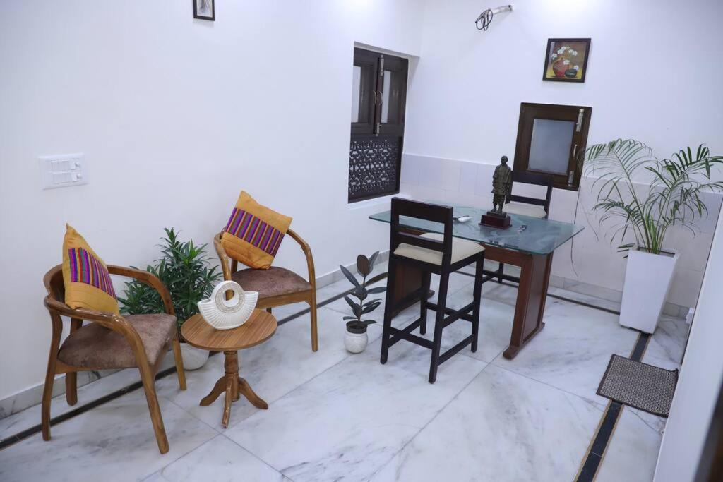 新德里的住宿－Fortune Home Service Apartment 1Bhk,L-36B,Saket，配有椅子、桌子和镜子的房间