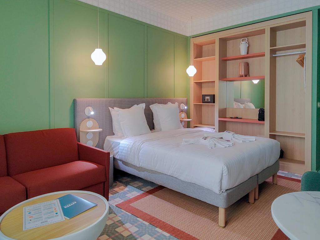 een slaapkamer met een bed en een rode stoel bij Aparthotel AMMI Nice Lafayette in Nice