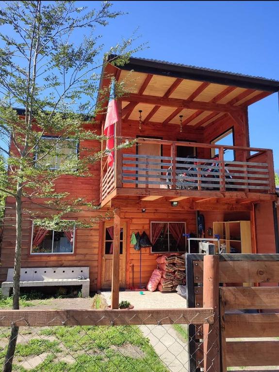 a log cabin with a deck and a balcony at cabaña de 2 pisos in Coñaripe