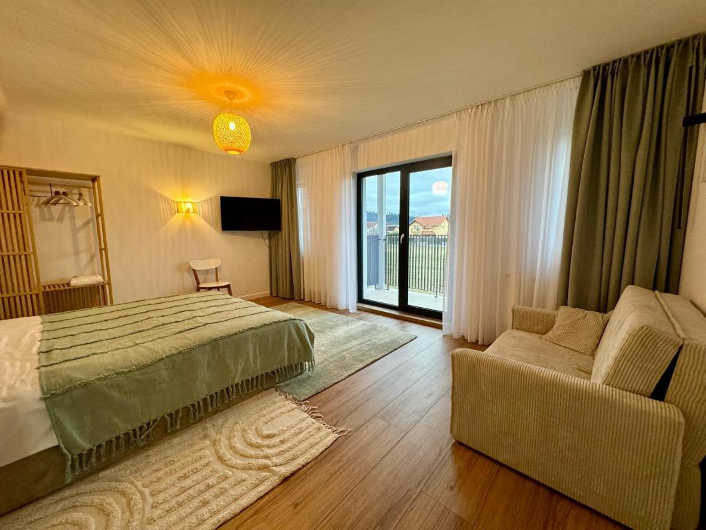 a bedroom with a bed and a couch and a window at EPIC Vila Brașov, Cristian in Braşov