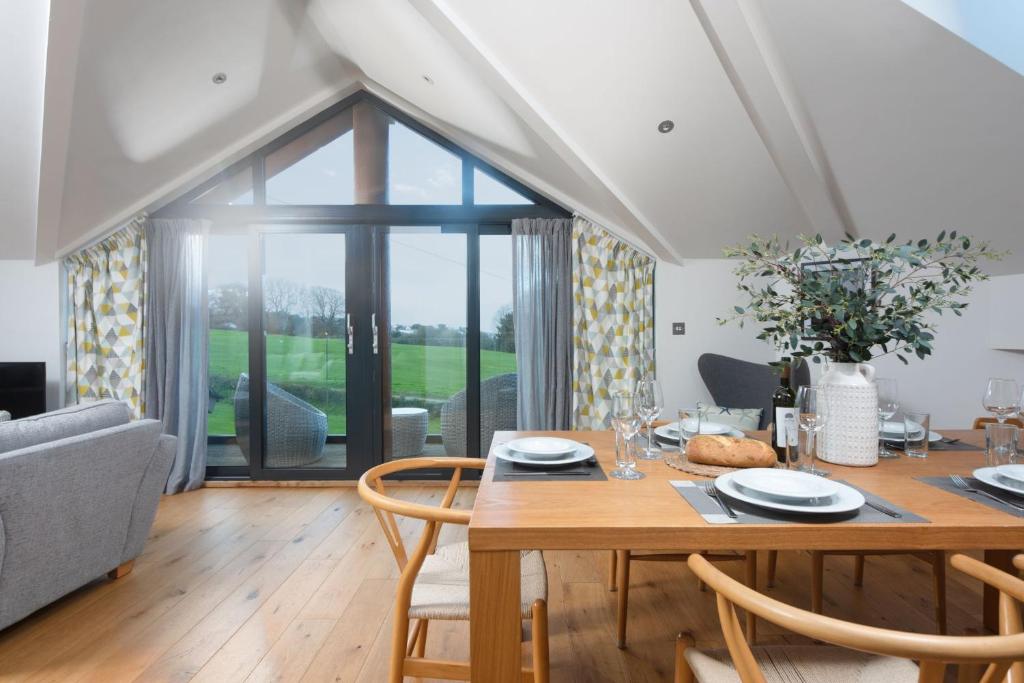 a dining room with a wooden table and chairs at The Paddock, Castle Approach, Tregenna Castle, St Ives in St Ives