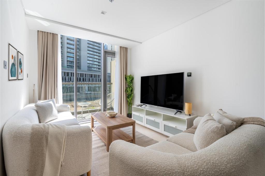 Premium Downtown apartment 2BD, 5 MIN DUBAI MALL في دبي: غرفة معيشة مع كنبتين وتلفزيون بشاشة مسطحة