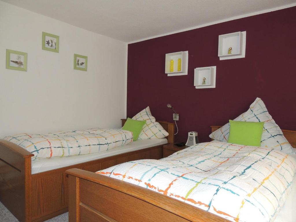 two beds in a room with purple walls at Pension Neuenrade in Neuenrade