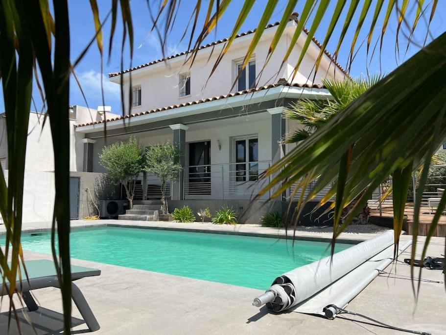 Maison avec piscine chauffée في ايمارغوس: بيت فيه مسبح قدام بيت