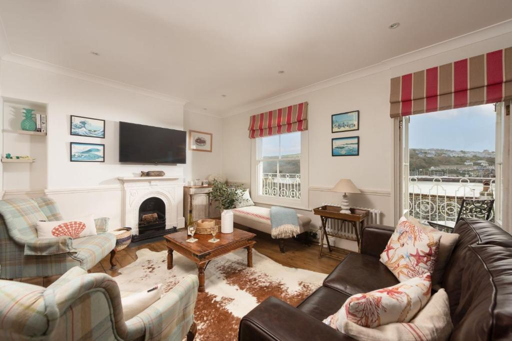 a living room with couches and a fireplace at La Folie, Fowey in Fowey