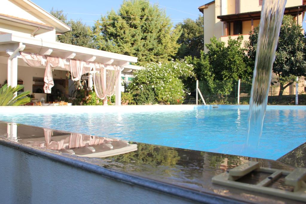 a swimming pool with a fountain in front of a building at A casa di Sandra, costa dei Trabocchi in Paglieta