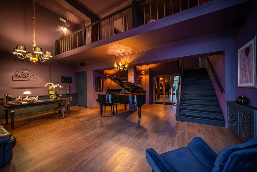 蒂米什瓦拉的住宿－Hotel Cocó，客厅配有三角钢琴和桌子
