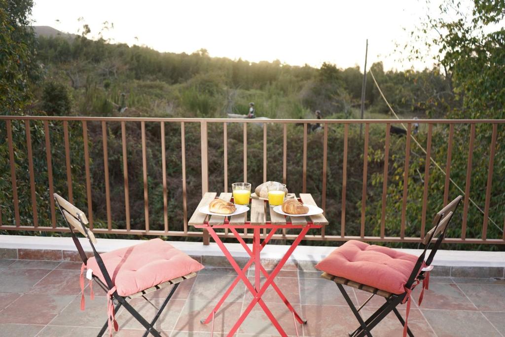 a table with food and two chairs on a balcony at Casa de campo 2 Ortigal Tenerife in La Esperanza