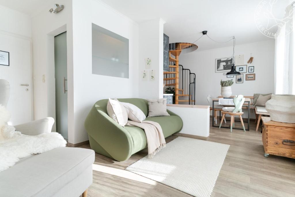 a living room with a green couch and a dining room at Appartements Lärchmoos in Ramsau am Dachstein