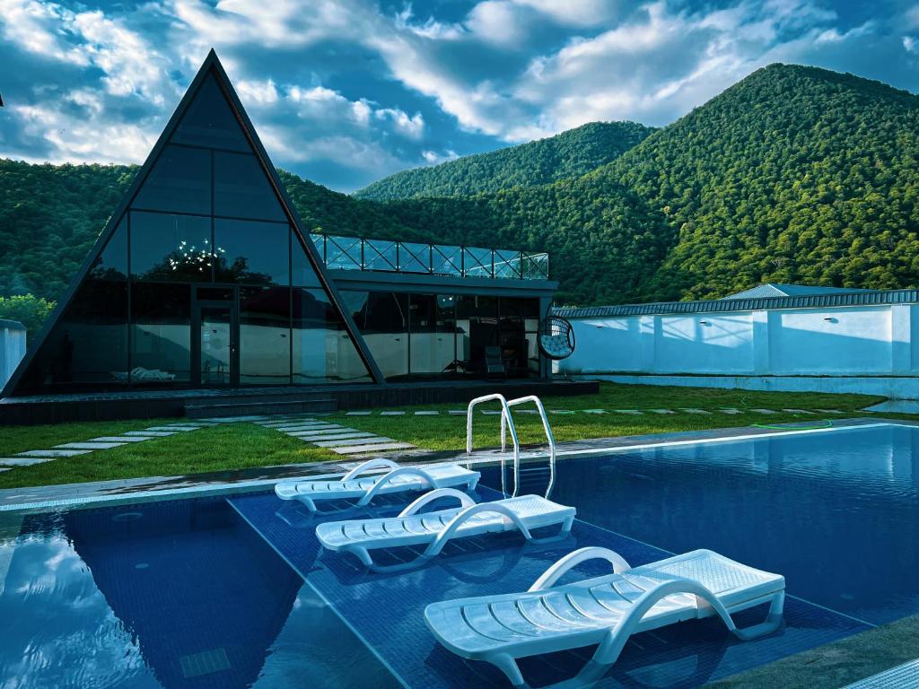 a resort with a swimming pool with a mountain at Qafqaz Royal Chalet in Gabala