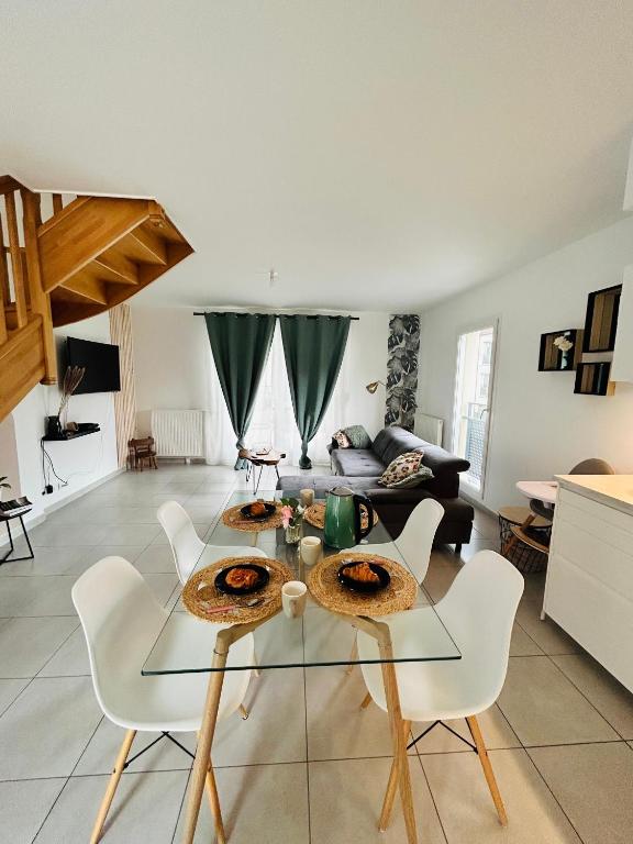 - un salon avec une table en verre et des chaises blanches dans l'établissement Disneyland Paris Familly Appart - 7 minutes Disney - Parking - Wifi, à Chessy