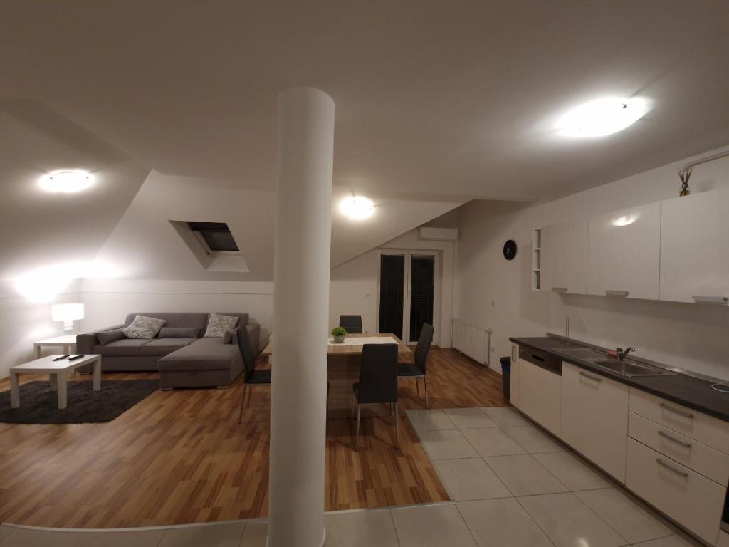 uma cozinha e sala de estar com um sofá e uma mesa em Apartman Sesvete em Sesvete