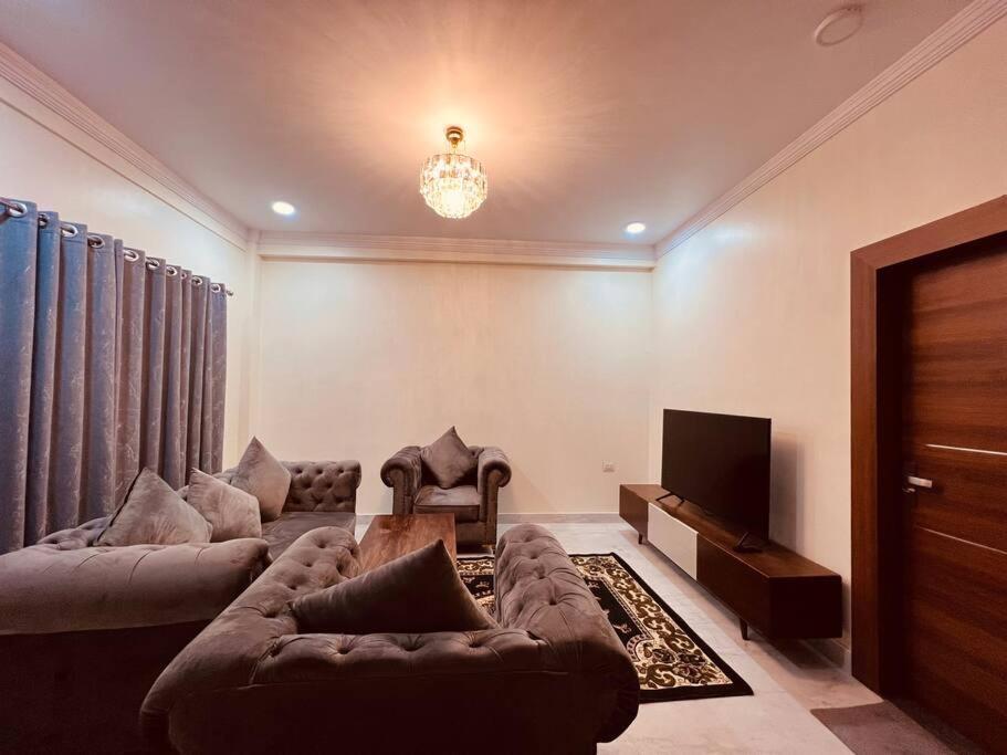 ein Wohnzimmer mit 2 Sofas und einem TV in der Unterkunft A beautiful cozy modern house. in Siddharthanagar