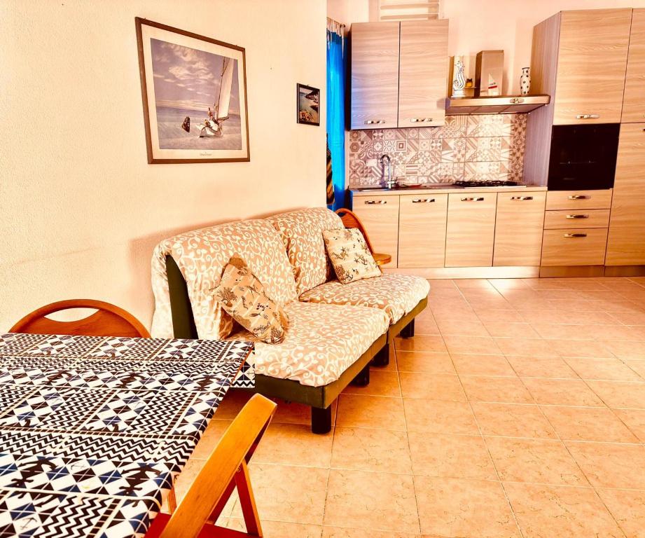 uma sala de estar com um sofá e uma cozinha em Nel cuore della città em La Maddalena