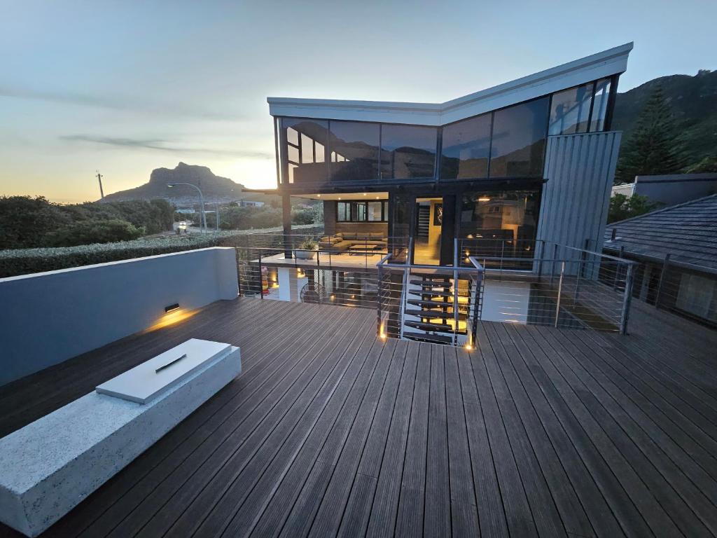 a large house with a wooden deck with a sunset at 1 On Royal in Cape Town