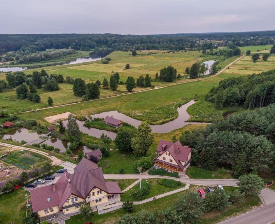 an aerial view of a house with a river in a field at Czar Podlasia agroturystyka in Osłowo