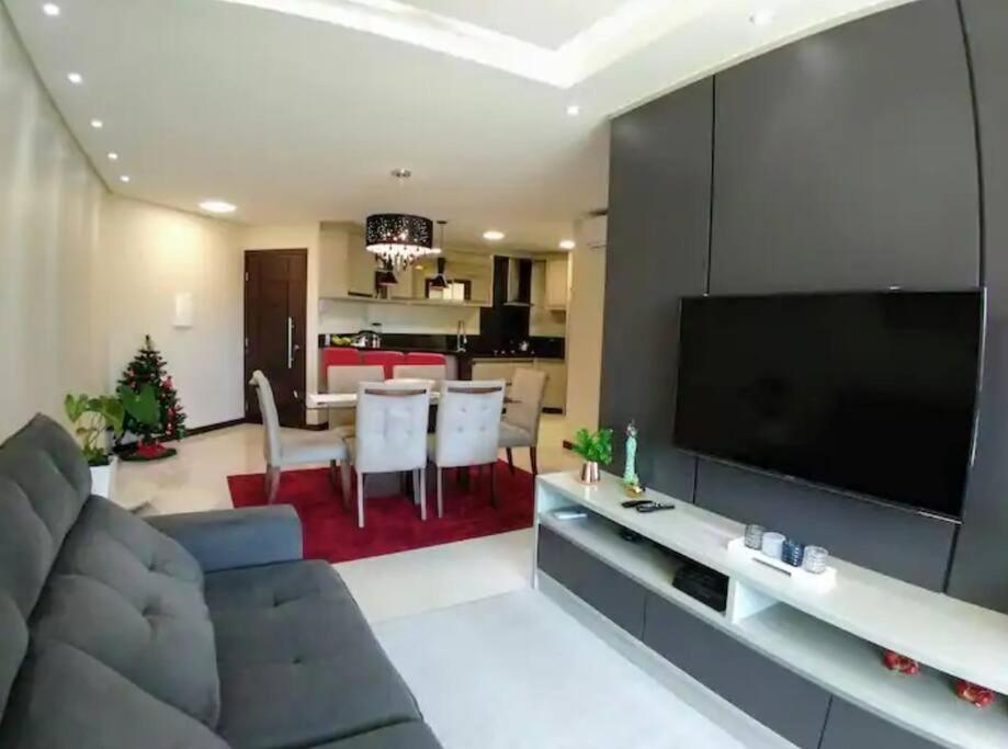 - un salon avec une grande télévision à écran plat dans l'établissement Lindo apartamento, a 300 m da Praia dos Ingleses!, à Florianópolis
