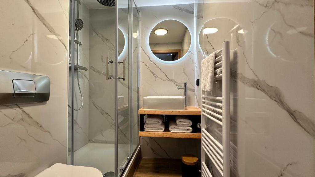 W łazience znajduje się prysznic i umywalka. w obiekcie Alpen Lodge Riezlern w mieście Riezlern