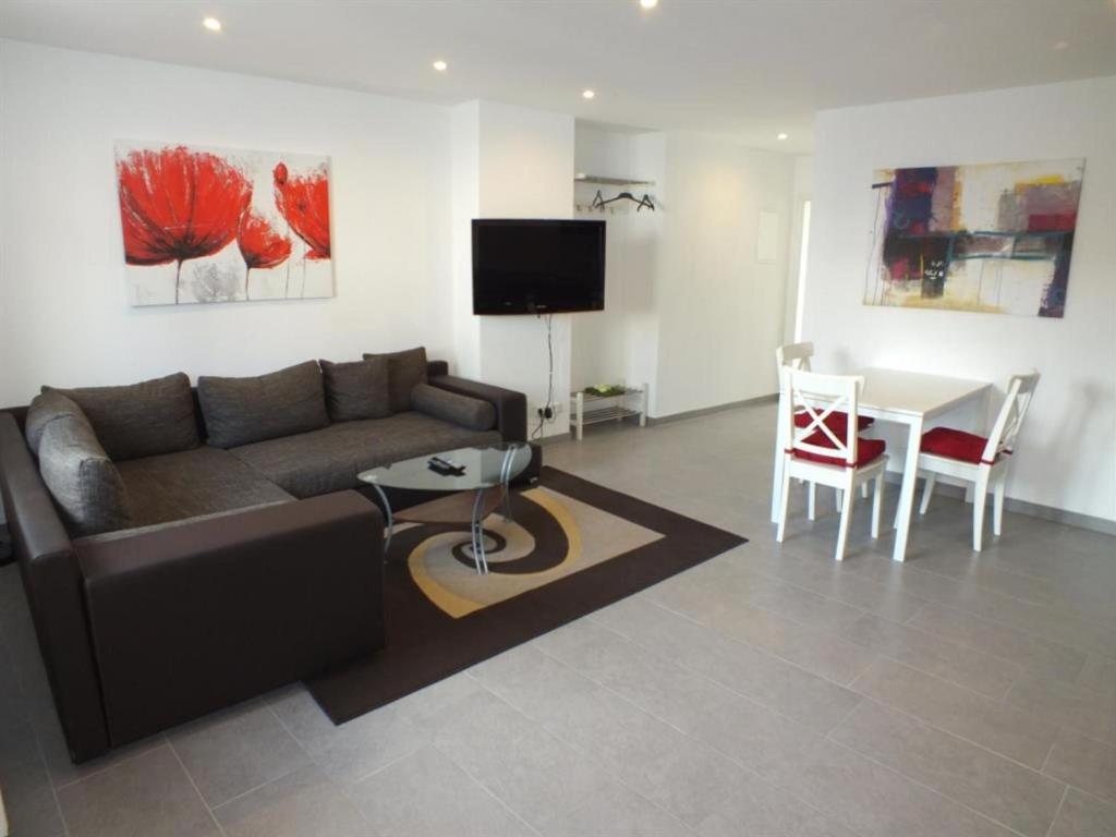 un salon avec un canapé et une table dans l'établissement Ferienwohnungen Moselterrasse, à Detzem