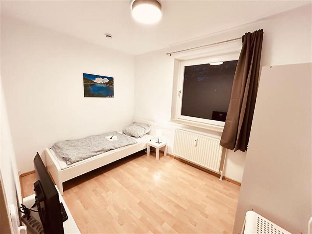 ein kleines Schlafzimmer mit einem Bett und einem Fenster in der Unterkunft Fully eqiupped apartment in Winsen (Luhe) in Winsen