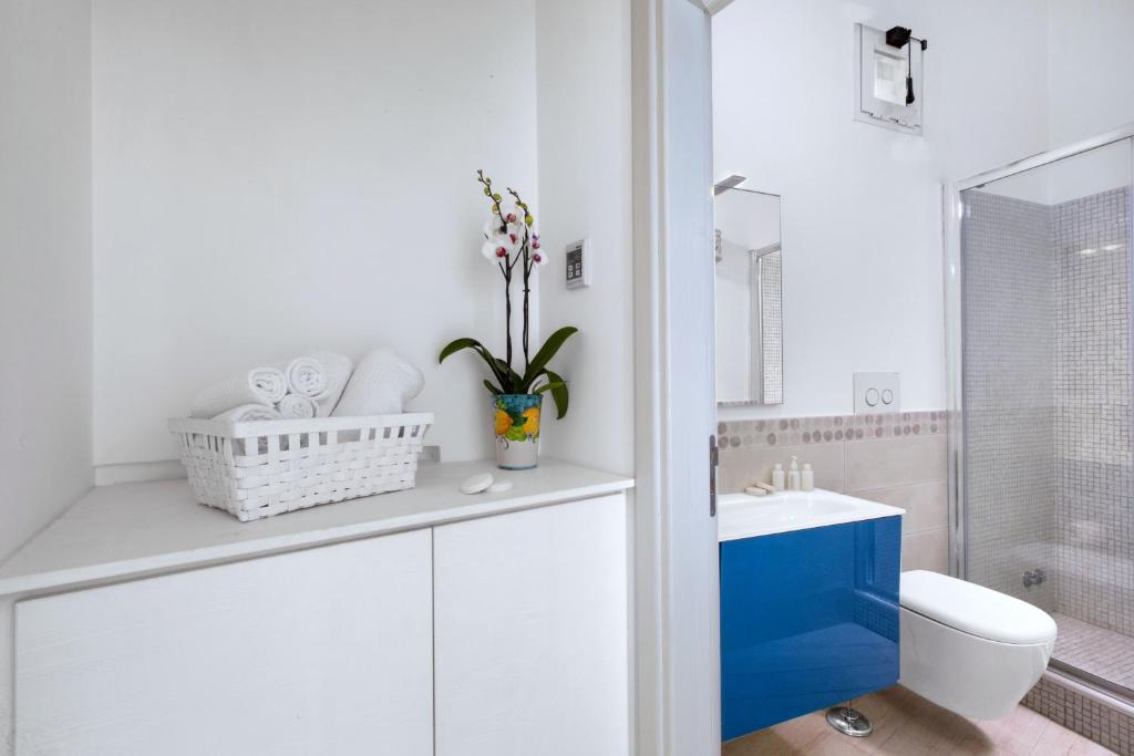 biała łazienka z toaletą i umywalką w obiekcie Amore Rentals - Villa Anna w mieście Positano