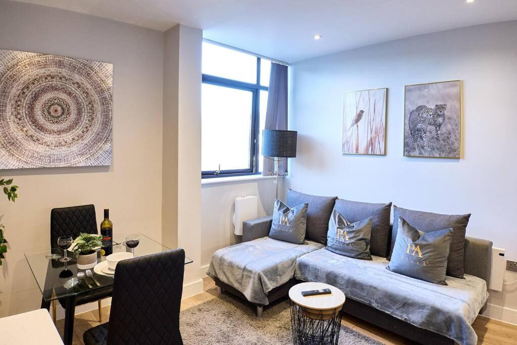 a living room with a couch and a table at Pluxa Arctic - College Road Retreat with Full Apt Full Access in Harrow on the Hill