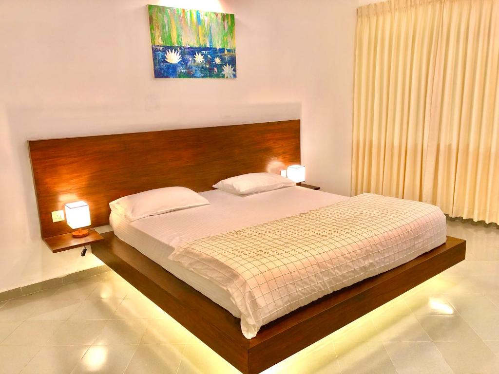 una camera con un grande letto e due lampade di Paradise Garden Beruwala a Beruwala