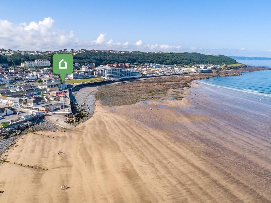 einen Blick über den Strand mit grünem Schild in der Unterkunft 1 Bed in Westward Ho NASEA in Westward Ho