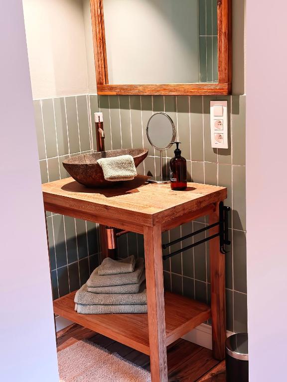 a bathroom with a sink and a mirror and towels at Vakantiehuis Maison Madeleine centrum Ieper in Ieper