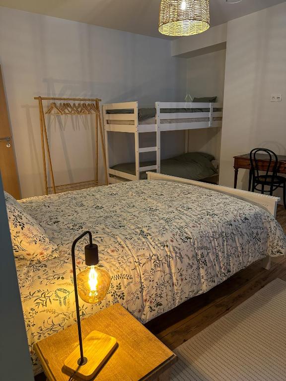 a bedroom with a bed and a table with a lamp at Vakantiehuis Maison Madeleine centrum Ieper in Ieper