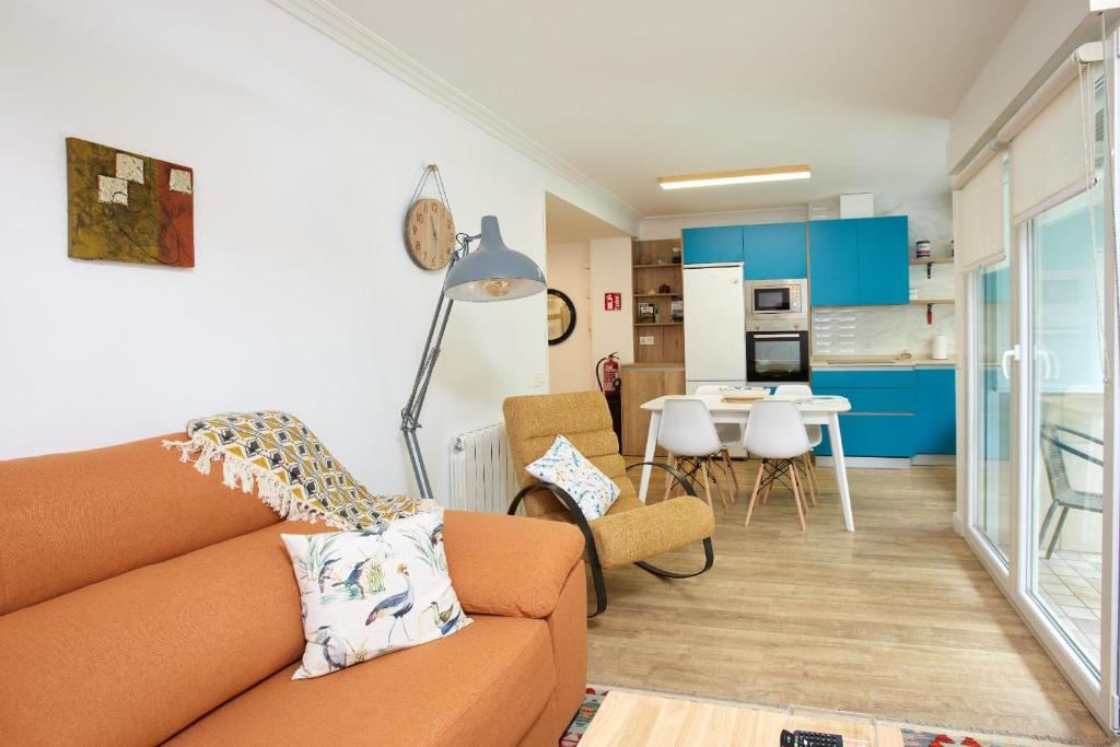 a living room with a couch and a kitchen at Itsasoa by Basque Homes in Donostia-San Sebastián
