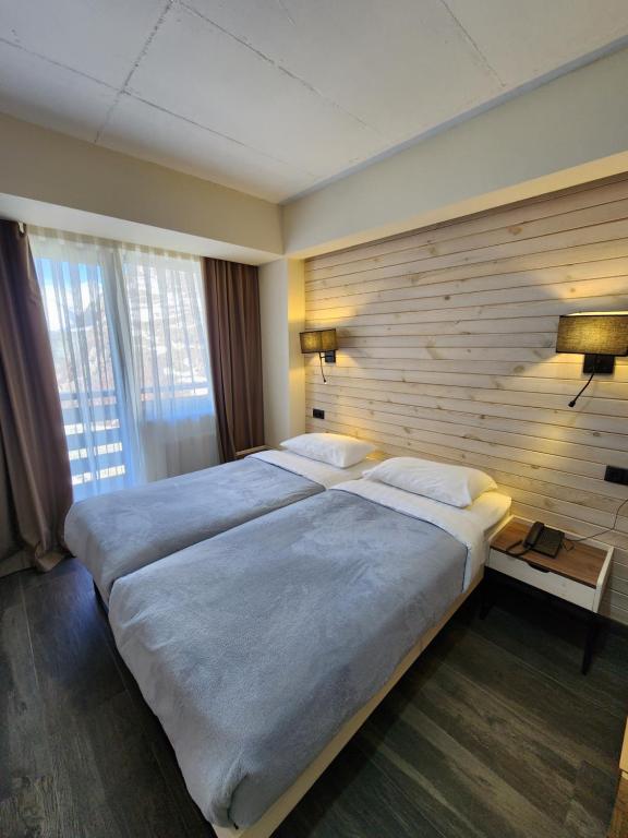 Postel nebo postele na pokoji v ubytování Gudauri Hills Apart Hotel