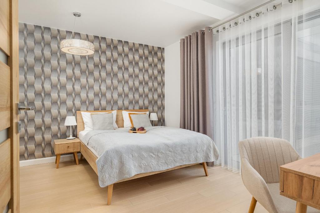 sypialnia z łóżkiem, krzesłem i oknem w obiekcie Balticus - Piękny Apartament 200 metrów od PLAŻY Międzyzdroje by Renters w mieście Międzyzdroje