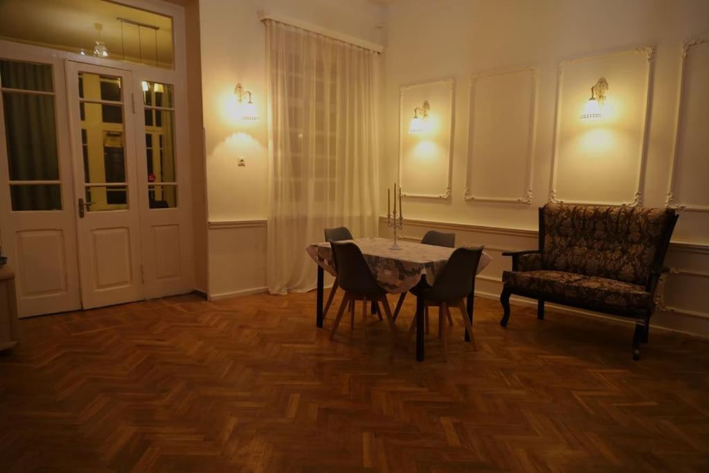 een eetkamer met een tafel en stoelen en een stoel bij Victoria apartment In Tbilisi in Tbilisi City