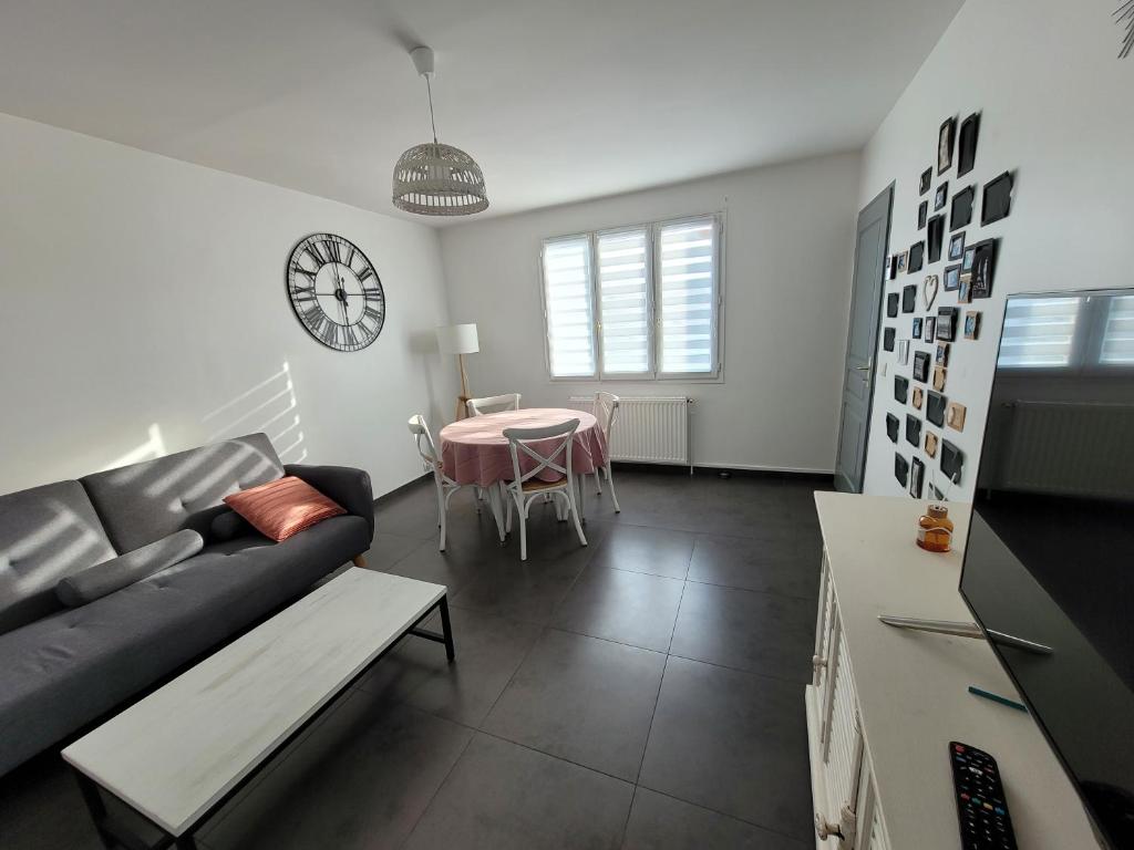 ein Wohnzimmer mit einem Sofa und einem Tisch in der Unterkunft Appartement F3 de 60M² à 20 minutes de Paris. in Yerres