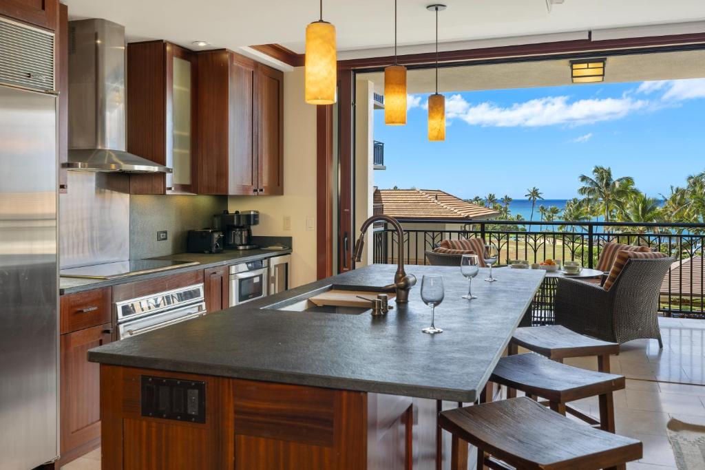 a kitchen with a table with wine glasses on it at Ko Olina Beach Villas O505 in Kapolei