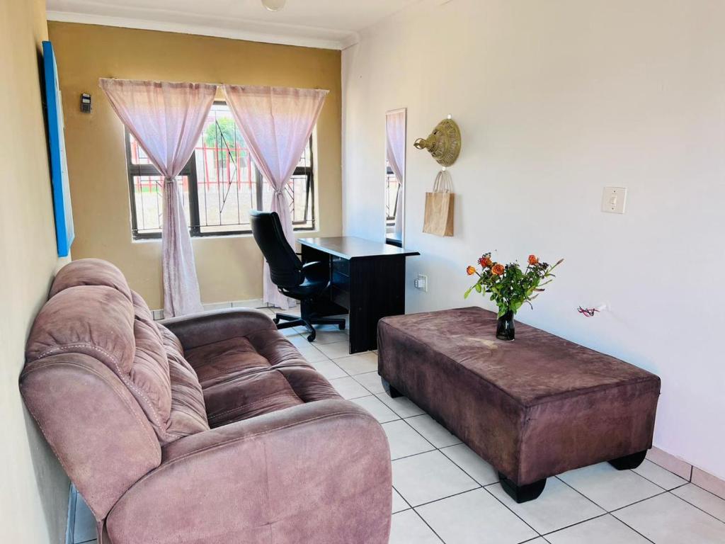 a living room with a couch and a desk at Mphatlalatsane Executive BnB in Maseru
