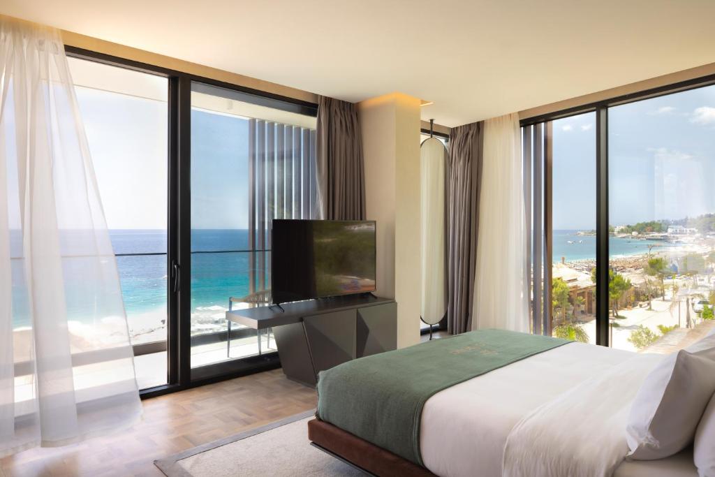 a hotel room with a bed and a large window at La Brisa Boutique Hotel in Dhërmi