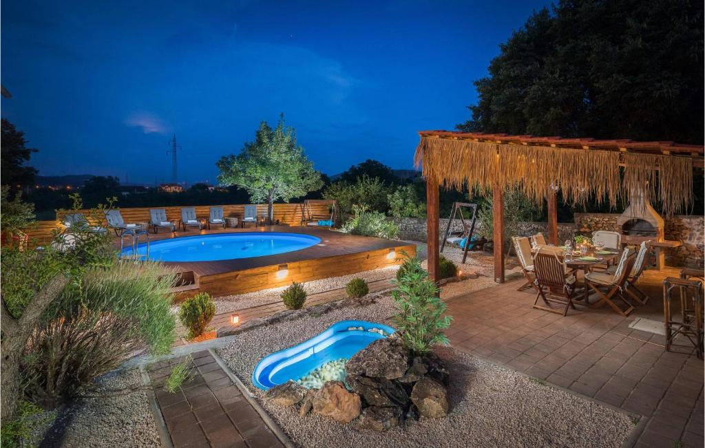 un cortile con piscina, tavolo e sedie di Nice Home In Bilice With Kitchen a Bilice (Bilizze)
