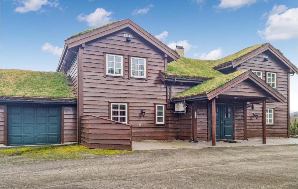 a house with a grass roof with a garage at 7 Bedroom Awesome Home In Tjrhom in Tjørhom