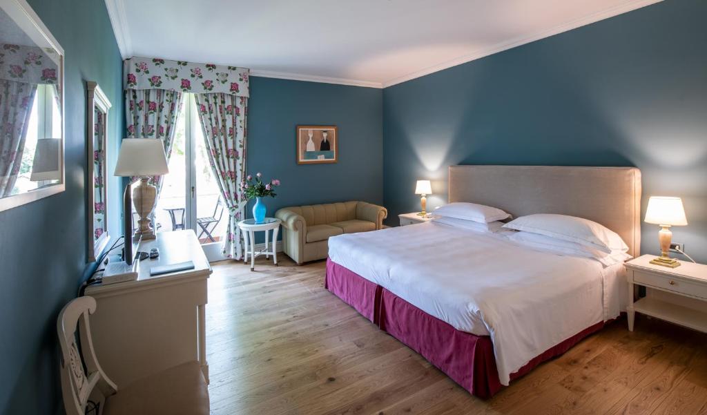 フォルテ・デイ・マルミにあるHotel Franceschiの青い壁のベッドルーム1室(大型ベッド1台付)