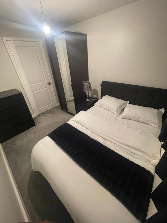 ein Schlafzimmer mit einem großen Bett mit einer schwarzen und weißen Decke in der Unterkunft Beautiful en-suite bedroom in Ipswich